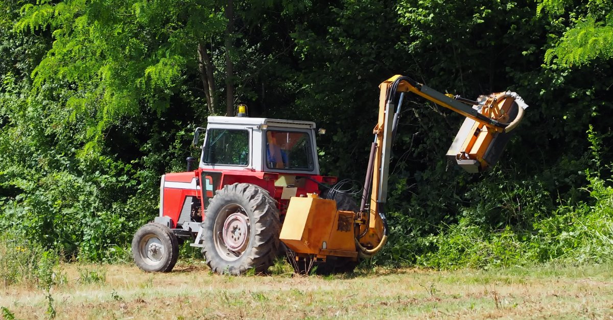 Tractor Using Brush Clearing Attachment in Forest